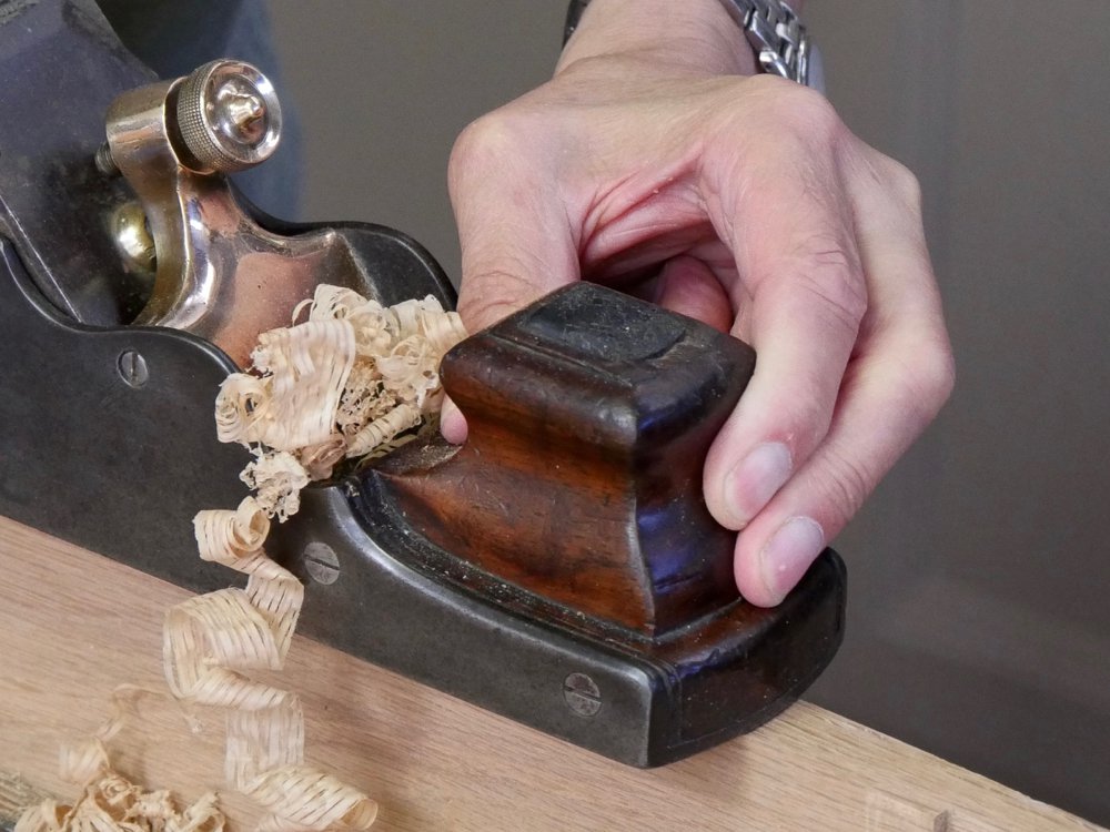 Shavings rise like plumes of smoke from this type of panel plane.